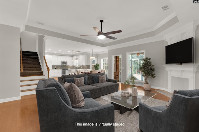 241 Highgrove Cir, West Columbia, SC 29170 - living room with a ceiling fan, a raised ceiling, stairway, light wood-type flooring, and ornamental molding