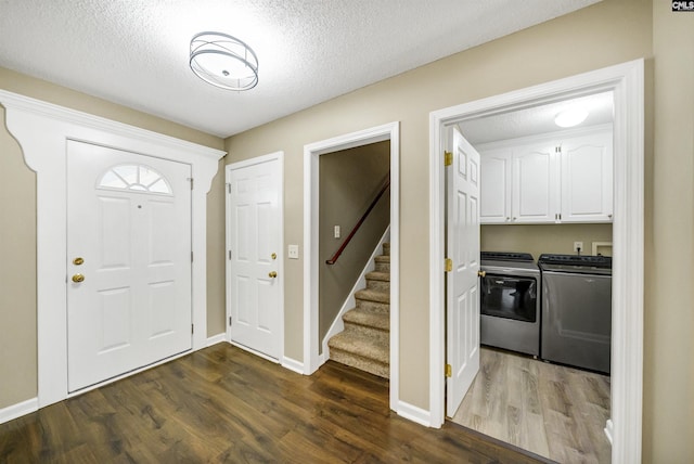 entryway with separate washer and dryer, dark hardwood / wood-style floors, and a textured ceiling