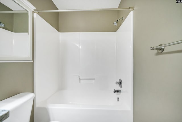 bathroom with bathing tub / shower combination and toilet