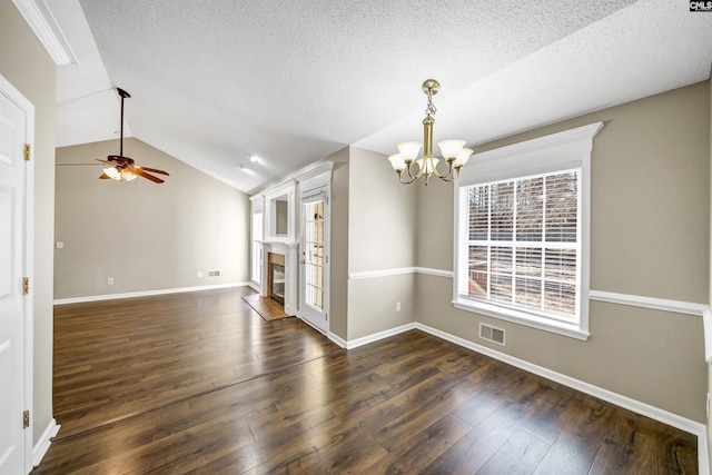 interior space with lofted ceiling, dark hardwood / wood-style flooring, ceiling fan with notable chandelier, and a textured ceiling