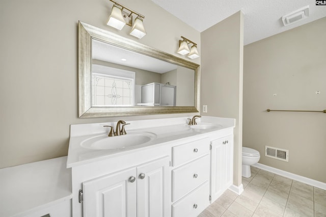 bathroom featuring vanity, an enclosed shower, toilet, tile patterned floors, and a textured ceiling