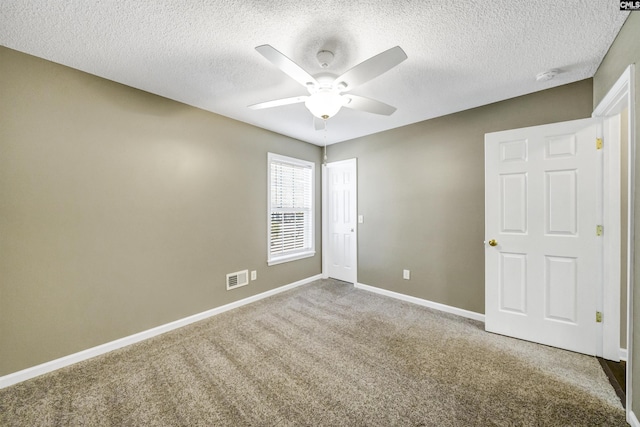 empty room with a textured ceiling, ceiling fan, and carpet flooring