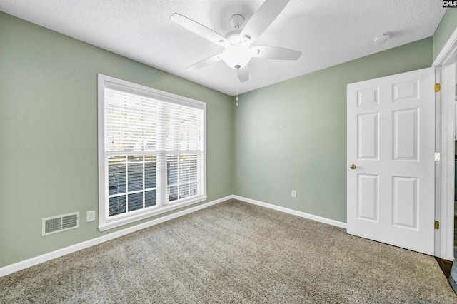 spare room with ceiling fan, carpet floors, and a textured ceiling