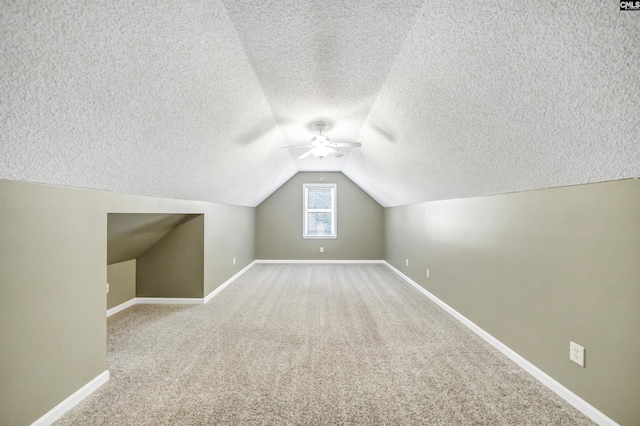 bonus room featuring carpet floors, vaulted ceiling, and a textured ceiling