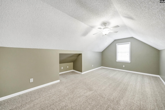 additional living space featuring lofted ceiling, ceiling fan, carpet floors, and a textured ceiling