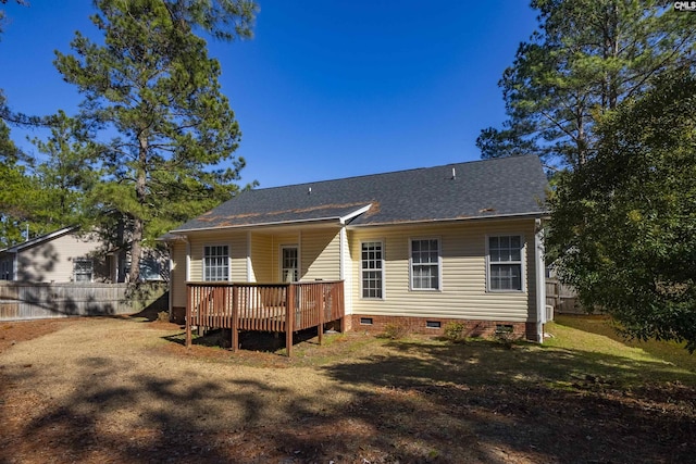 back of property featuring a deck and a lawn