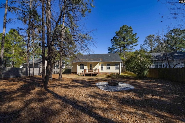 rear view of property with an outdoor fire pit and a deck