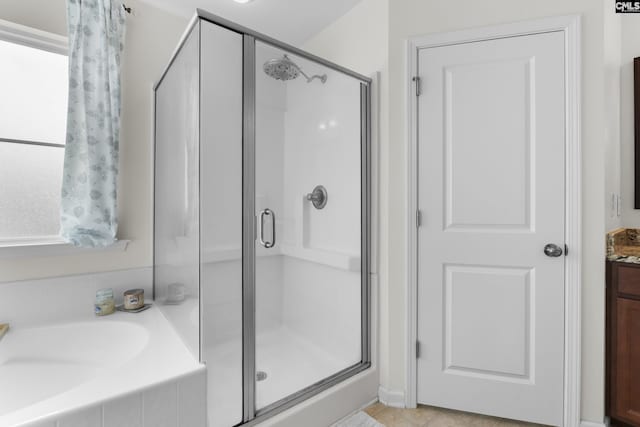 bathroom featuring tile patterned flooring, shower with separate bathtub, and vanity