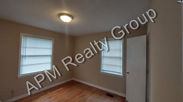 unfurnished room with wood-type flooring