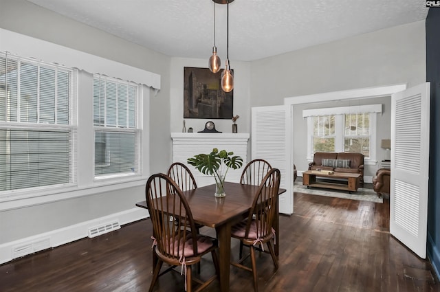 dining space with a textured ceiling and dark hardwood / wood-style flooring