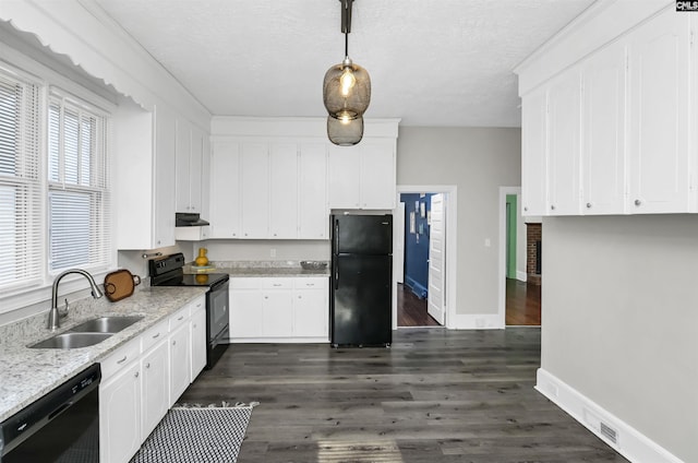 kitchen with sink, light stone counters, white cabinetry, decorative light fixtures, and black appliances