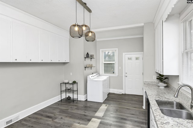 kitchen featuring white cabinetry, sink, light stone counters, and washing machine and clothes dryer