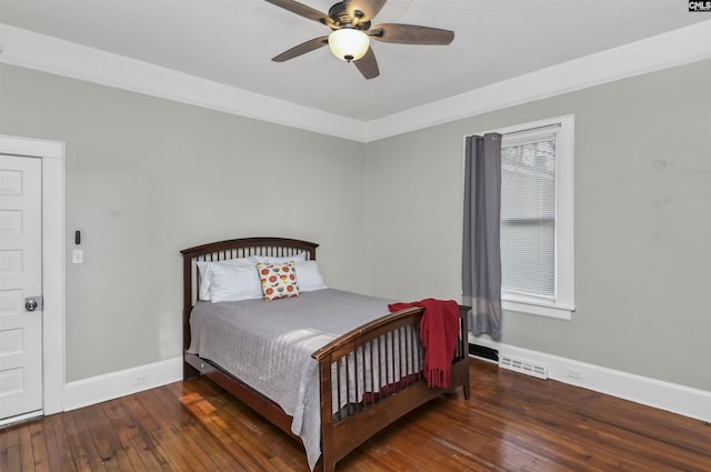 bedroom with crown molding, dark hardwood / wood-style floors, and ceiling fan