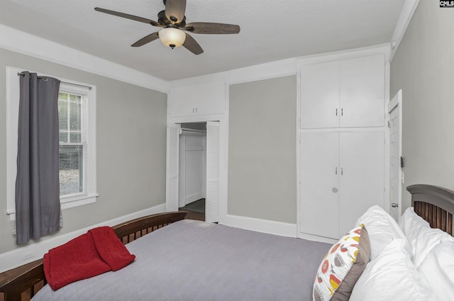 bedroom with ceiling fan, a textured ceiling, and two closets