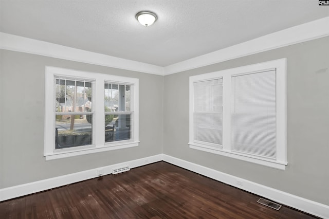 unfurnished room featuring hardwood / wood-style flooring and a textured ceiling