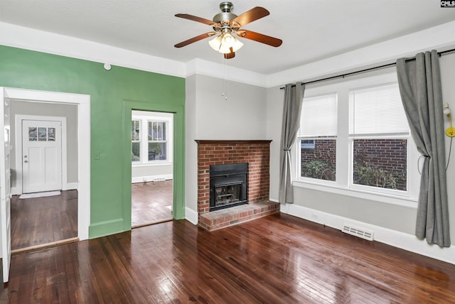 unfurnished living room featuring hardwood / wood-style flooring, a brick fireplace, and ceiling fan