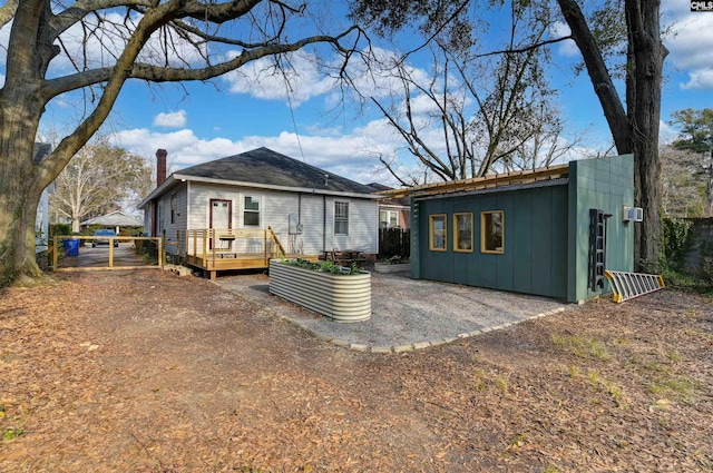 rear view of house featuring a wooden deck