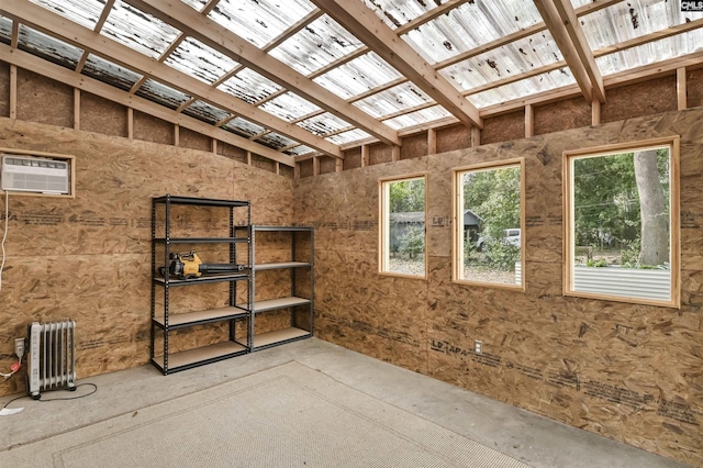 interior space with radiator, a wall mounted air conditioner, and a skylight