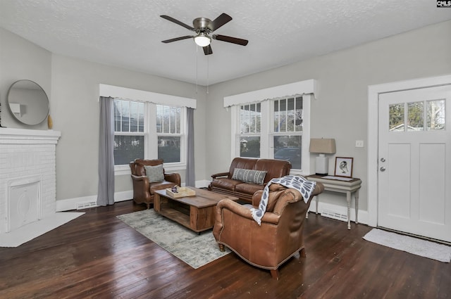 living room with ceiling fan, dark hardwood / wood-style floors, and a textured ceiling