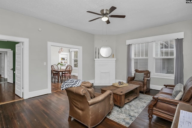 living room with ceiling fan, dark hardwood / wood-style floors, and a textured ceiling