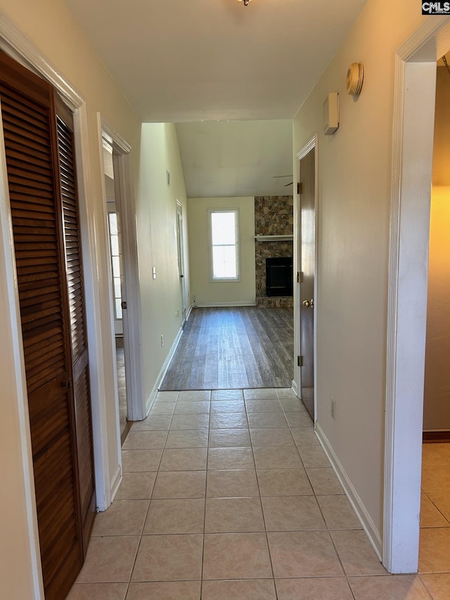 hall featuring vaulted ceiling and light tile patterned floors