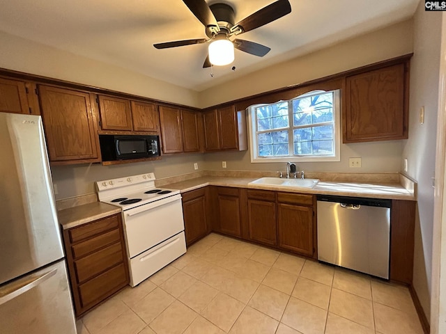 kitchen featuring stainless steel appliances, light tile patterned flooring, sink, and ceiling fan