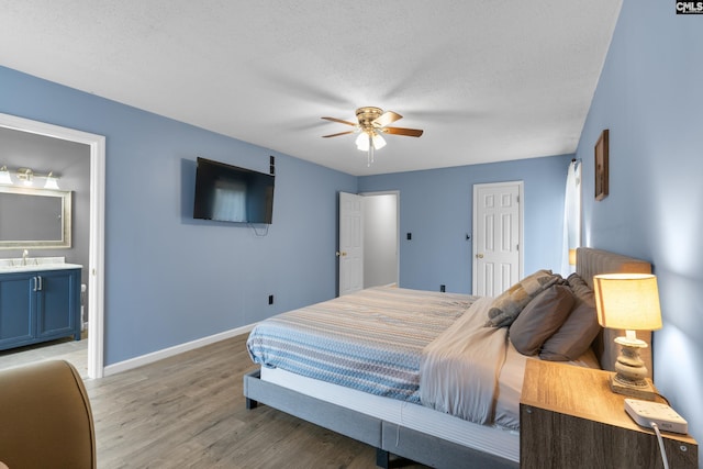 bedroom with connected bathroom, hardwood / wood-style floors, ceiling fan, a textured ceiling, and a closet