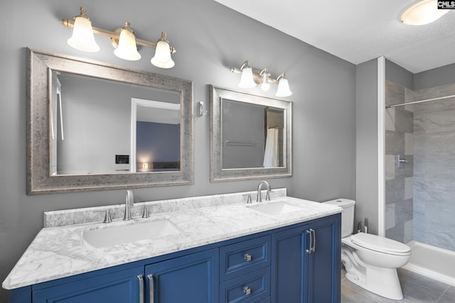 bathroom with toilet, a textured ceiling, a tile shower, vanity, and tile patterned flooring