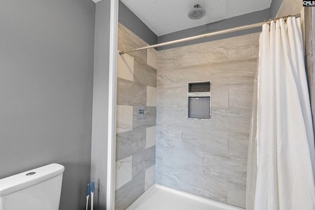 bathroom with walk in shower, toilet, and a textured ceiling