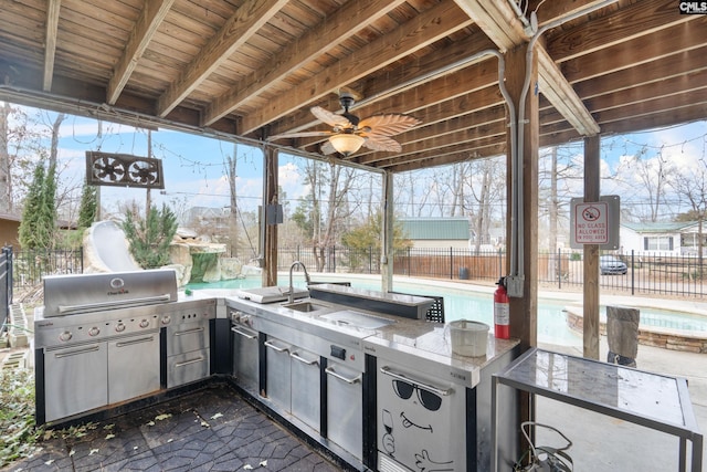 view of patio / terrace with ceiling fan, area for grilling, a fenced in pool, and a wet bar