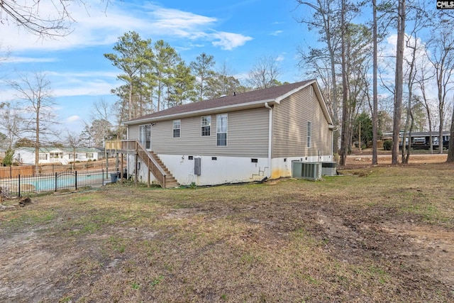 rear view of property with a wooden deck, a lawn, and central air condition unit