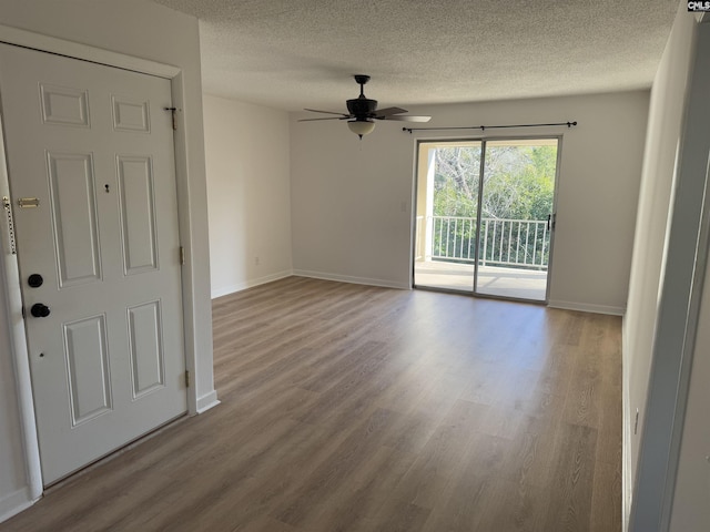 empty room with ceiling fan, light hardwood / wood-style flooring, and a textured ceiling