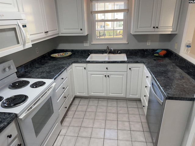 kitchen featuring white cabinetry, sink, white appliances, and light tile patterned flooring