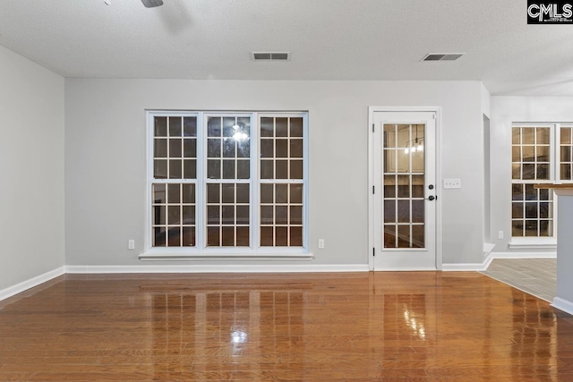 spare room with wood-type flooring and a textured ceiling