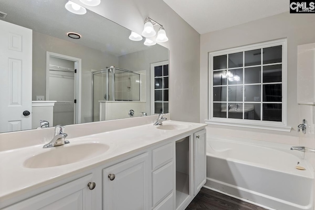 bathroom featuring shower with separate bathtub, hardwood / wood-style floors, and vanity