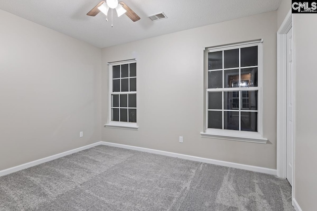 carpeted spare room with a textured ceiling and ceiling fan