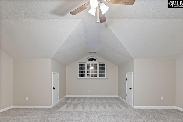 bonus room with light carpet, ceiling fan, vaulted ceiling, and a textured ceiling