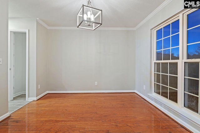 unfurnished dining area with crown molding, wood-type flooring, and a chandelier