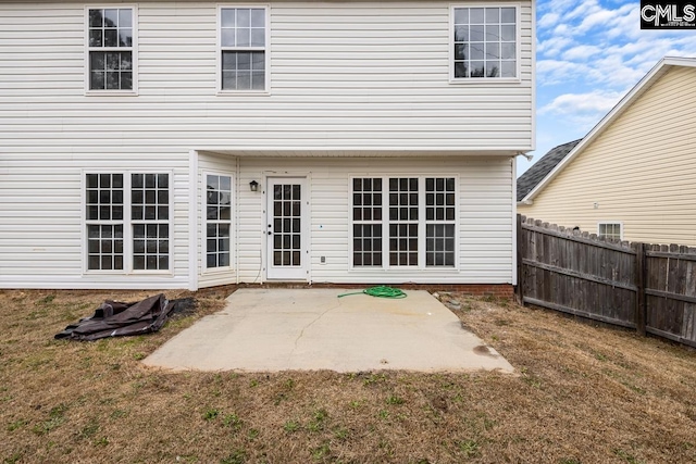 back of property with a patio area and a lawn