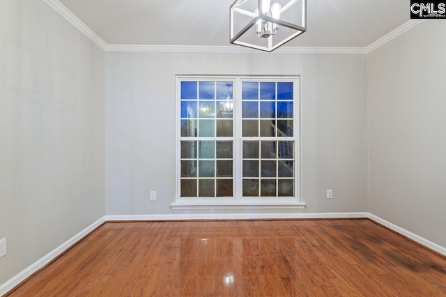 unfurnished room featuring crown molding, a chandelier, and hardwood / wood-style floors