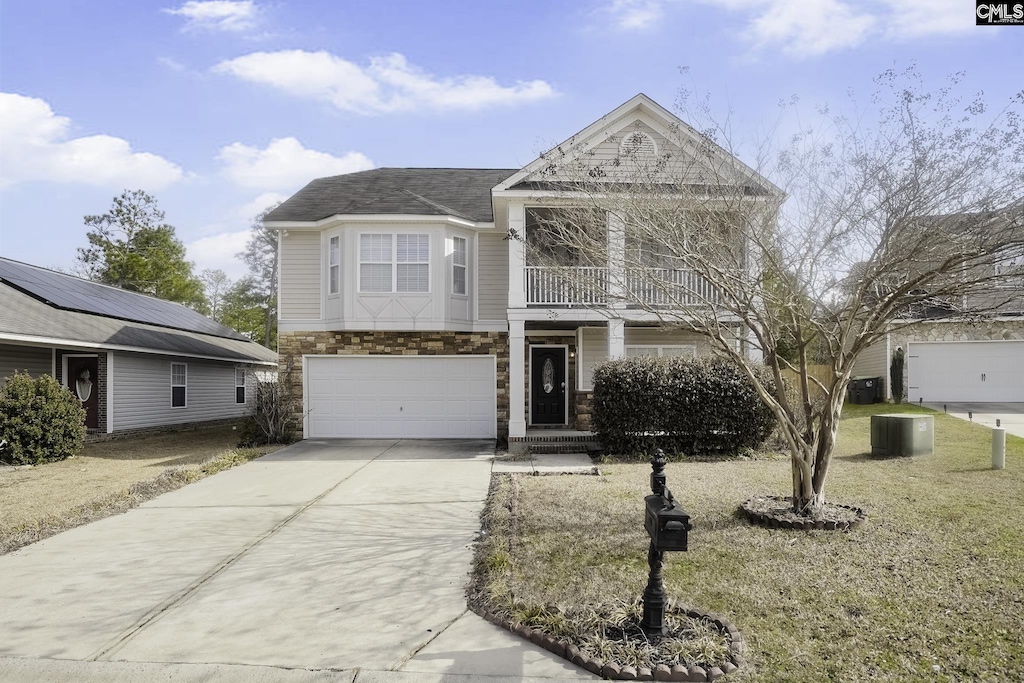 view of front of home with a garage, a balcony, and central AC