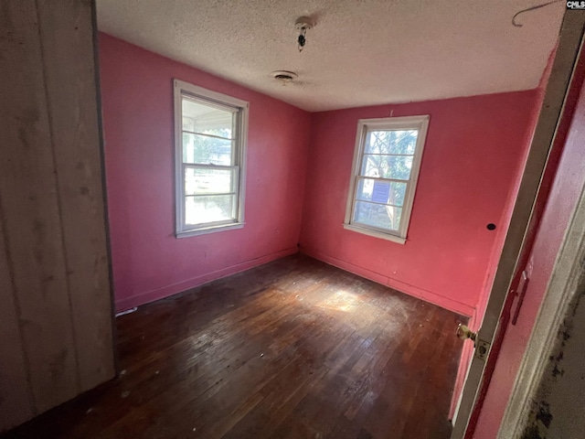 spare room with dark hardwood / wood-style flooring and a textured ceiling