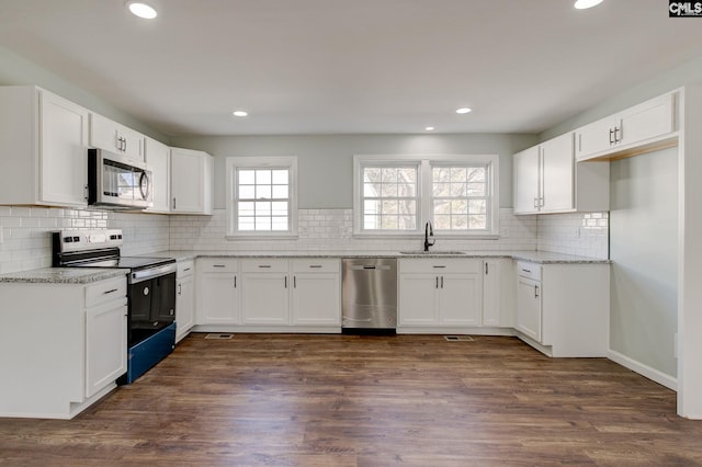 kitchen featuring stainless steel appliances, dark hardwood / wood-style flooring, sink, and white cabinets