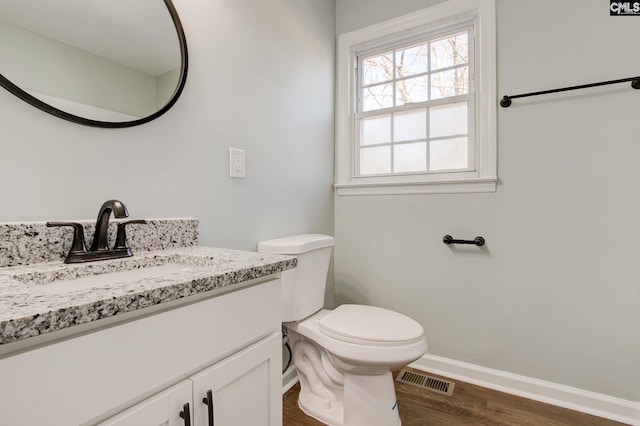 bathroom featuring vanity, hardwood / wood-style flooring, and toilet