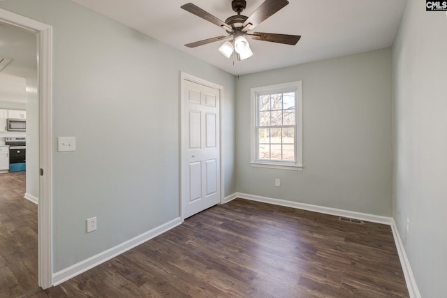 unfurnished bedroom featuring dark wood-type flooring, ceiling fan, and a closet