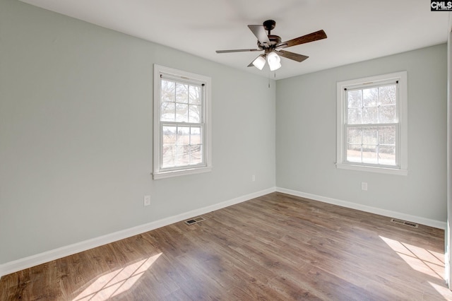 spare room featuring ceiling fan, a healthy amount of sunlight, and light hardwood / wood-style floors