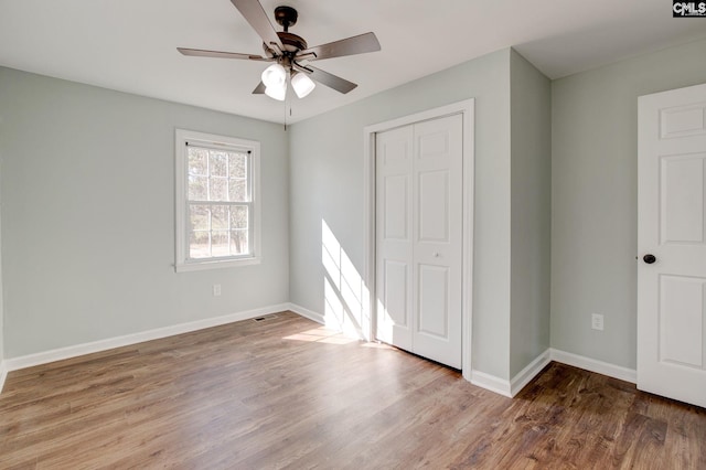 unfurnished bedroom with hardwood / wood-style flooring, ceiling fan, and a closet