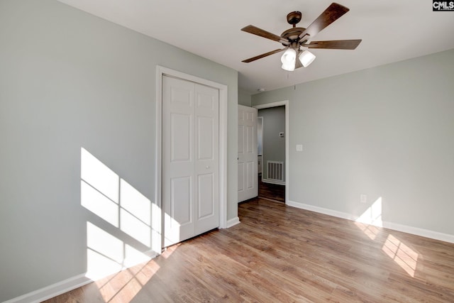 unfurnished bedroom with light hardwood / wood-style floors, a closet, and ceiling fan