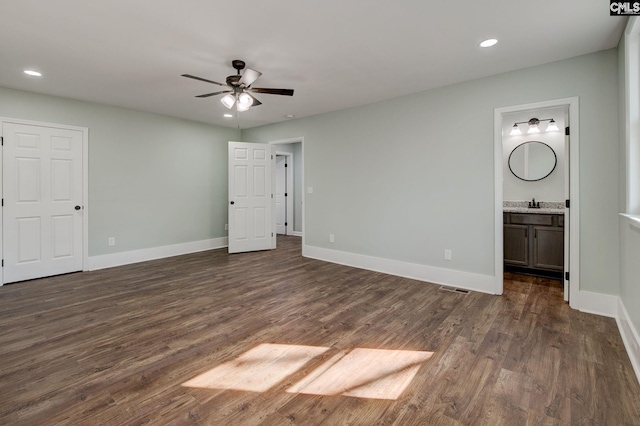 unfurnished bedroom with ensuite bathroom, sink, ceiling fan, and dark hardwood / wood-style flooring