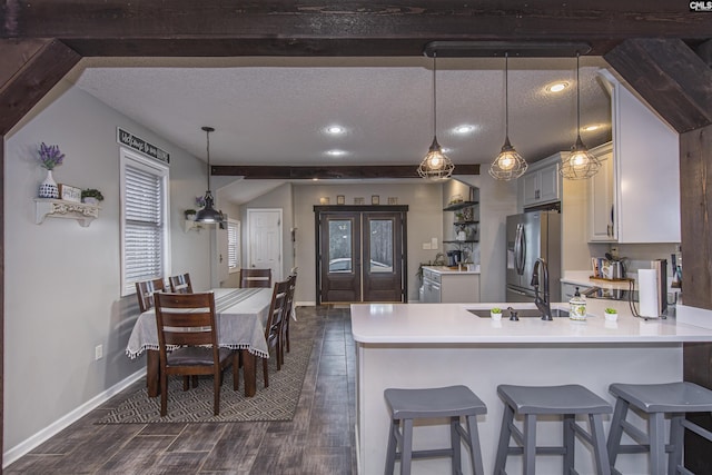 kitchen with pendant lighting, stainless steel fridge, kitchen peninsula, and a textured ceiling